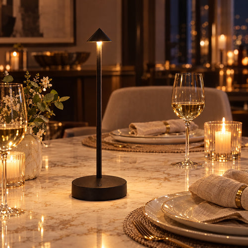Black Perch cordless table lamp glowing on a dining table